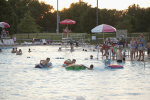 Kids playing in pool at sunset