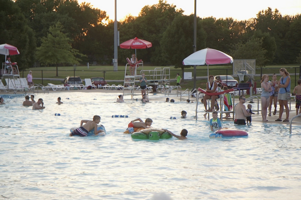 Kids playing in pool at sunset