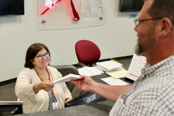 Front Desk Handing Customer Paper