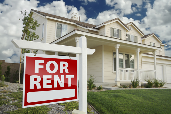 For rent sign in front of a white house