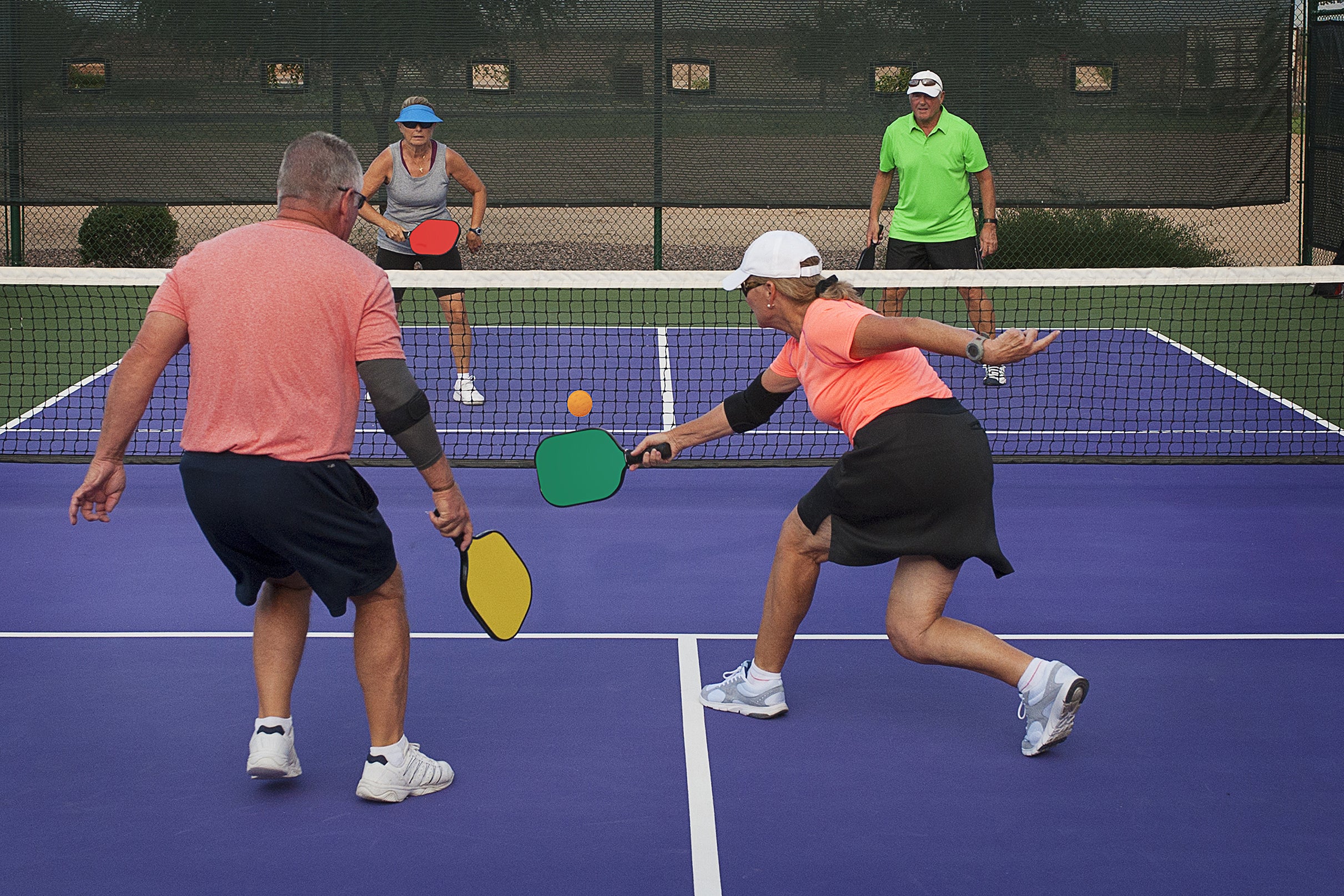 Four adults playing pickleball