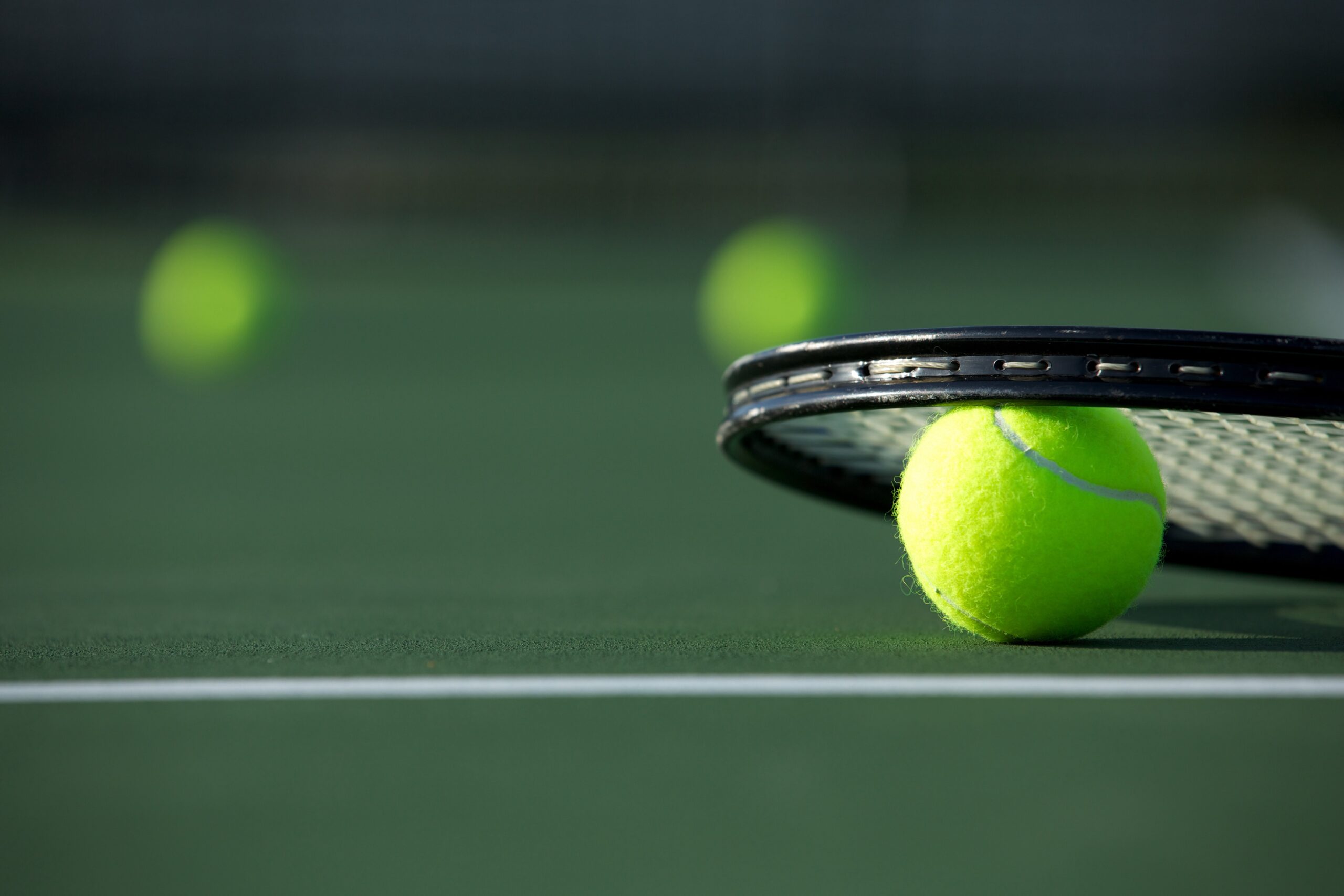 Tennis balls and a tennis racket on a tennis court