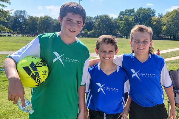 Three boys on a soccer field