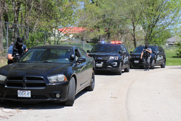 Three police cars and an officer participating in field training