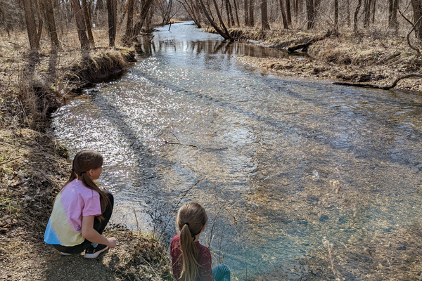 Two girls by a creek