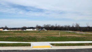 Photo shows empty lots waiting for the construction of homes. Roadway infrastructure is fully built-out.
